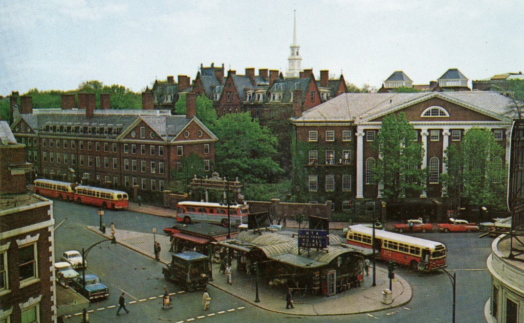 An image of historic Harvard square from above. The Kiosk is in the center of a busy road with Harvard campus in the background.