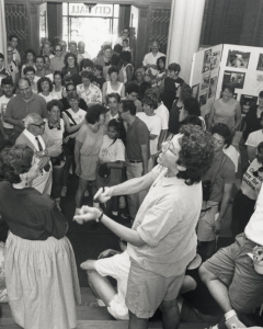 black and white photo depicting a large room filled with people
