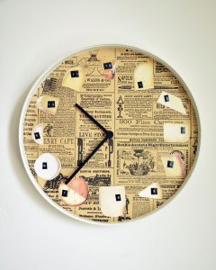 a clock face collaged with newsprint and different photos of cheese to represent the numbers