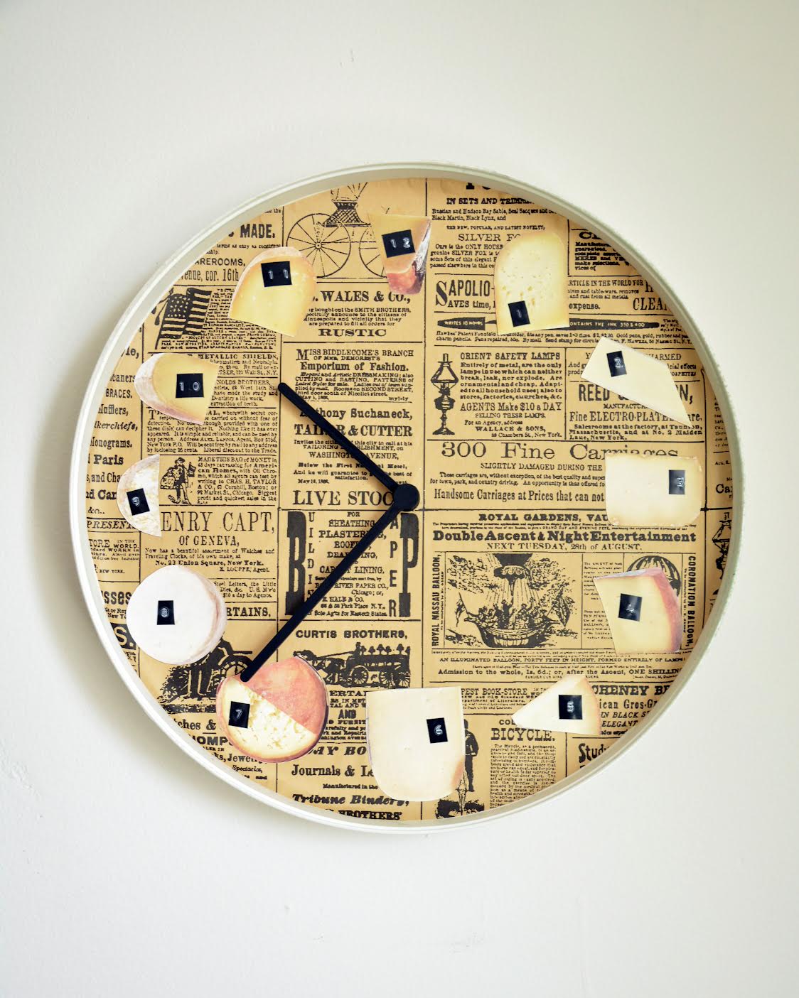 a clock face collaged with newsprint and different photos of cheese to represent the numbers
