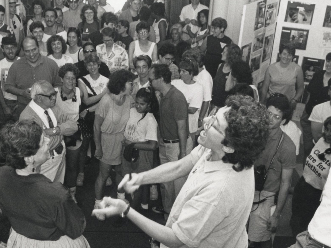 black and white photo depicting a large room filled with people