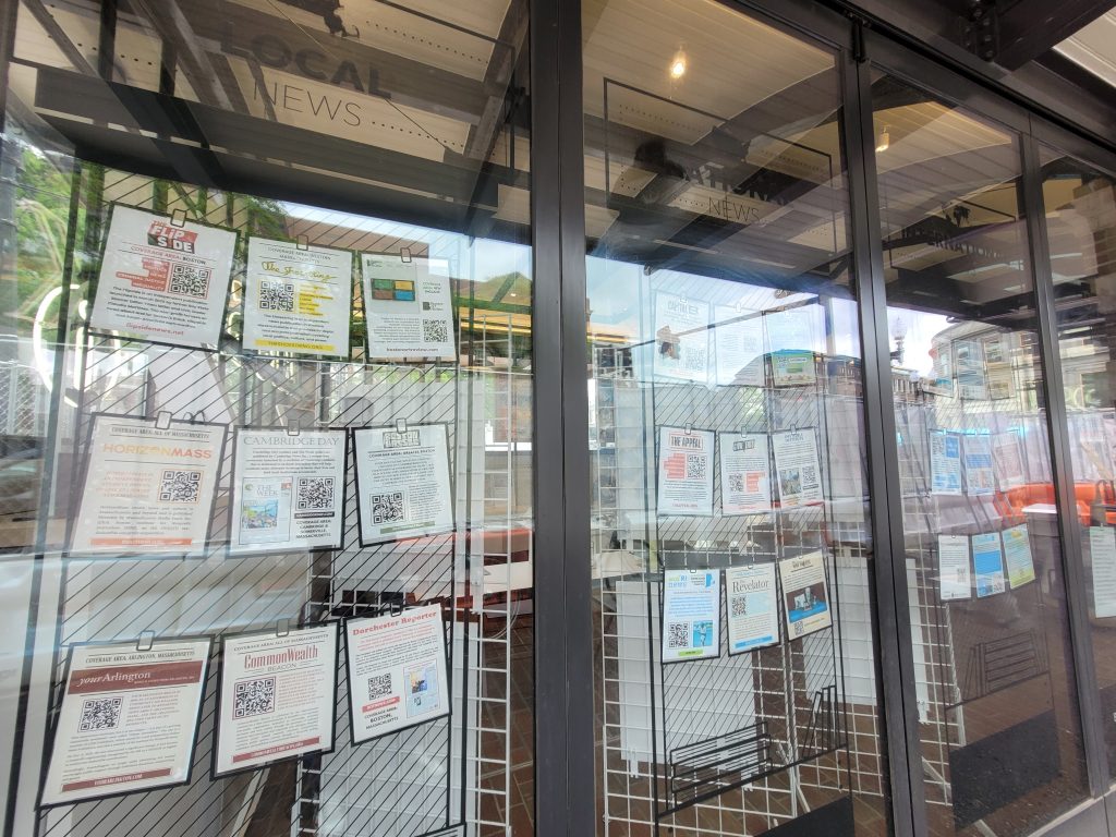 Framed newsprint from various local publications hang on the front doors of the KiOSK as part of the Cambridge: Then and Now exhibition.