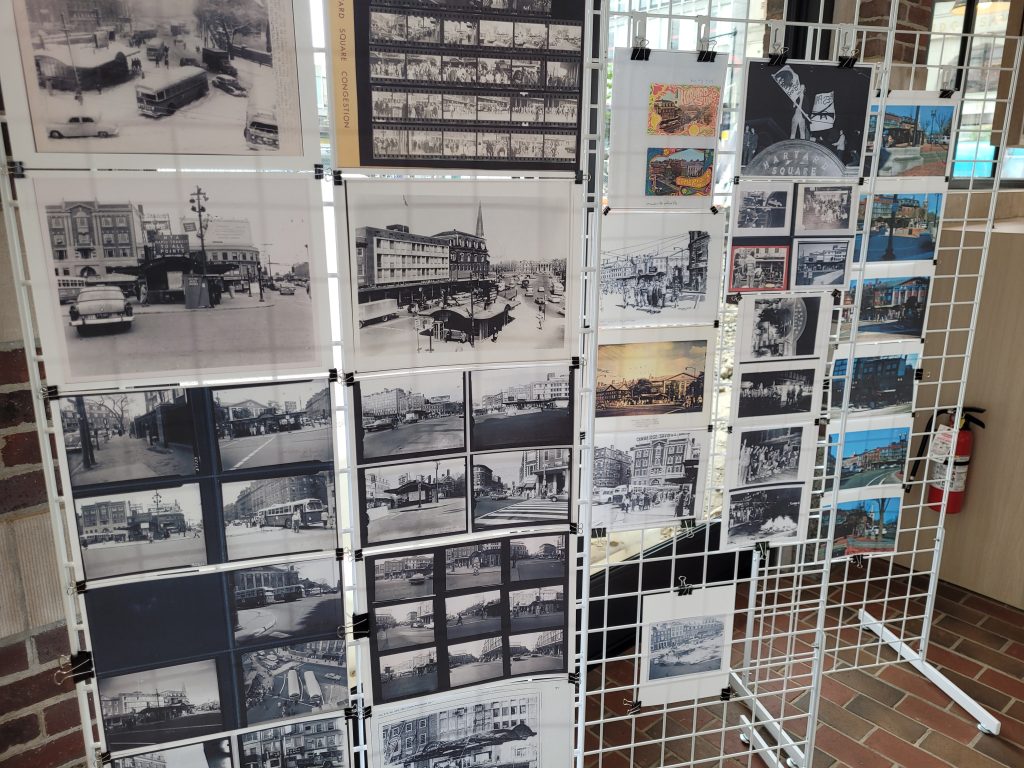 Old images of Harvard Square hang on wire grids on the left, while more recent images of what the area looks like today hang in sharp contrast on the right.