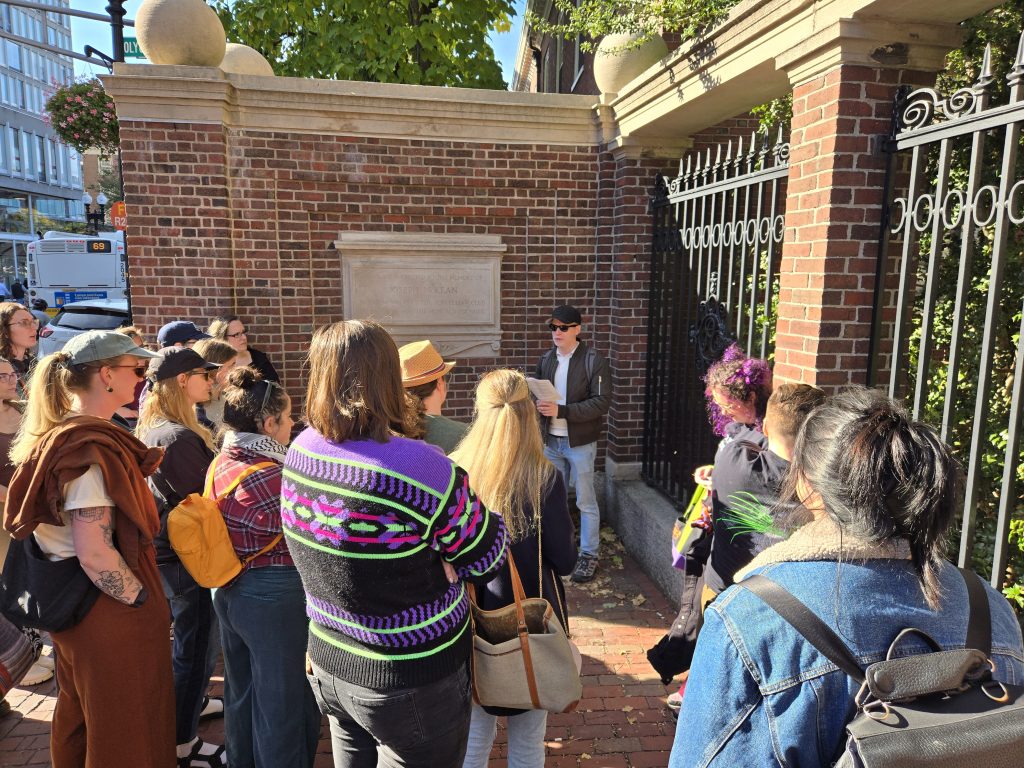 Visitors gather to listen at a stop along a walking tour for the Queer History exhibition.
