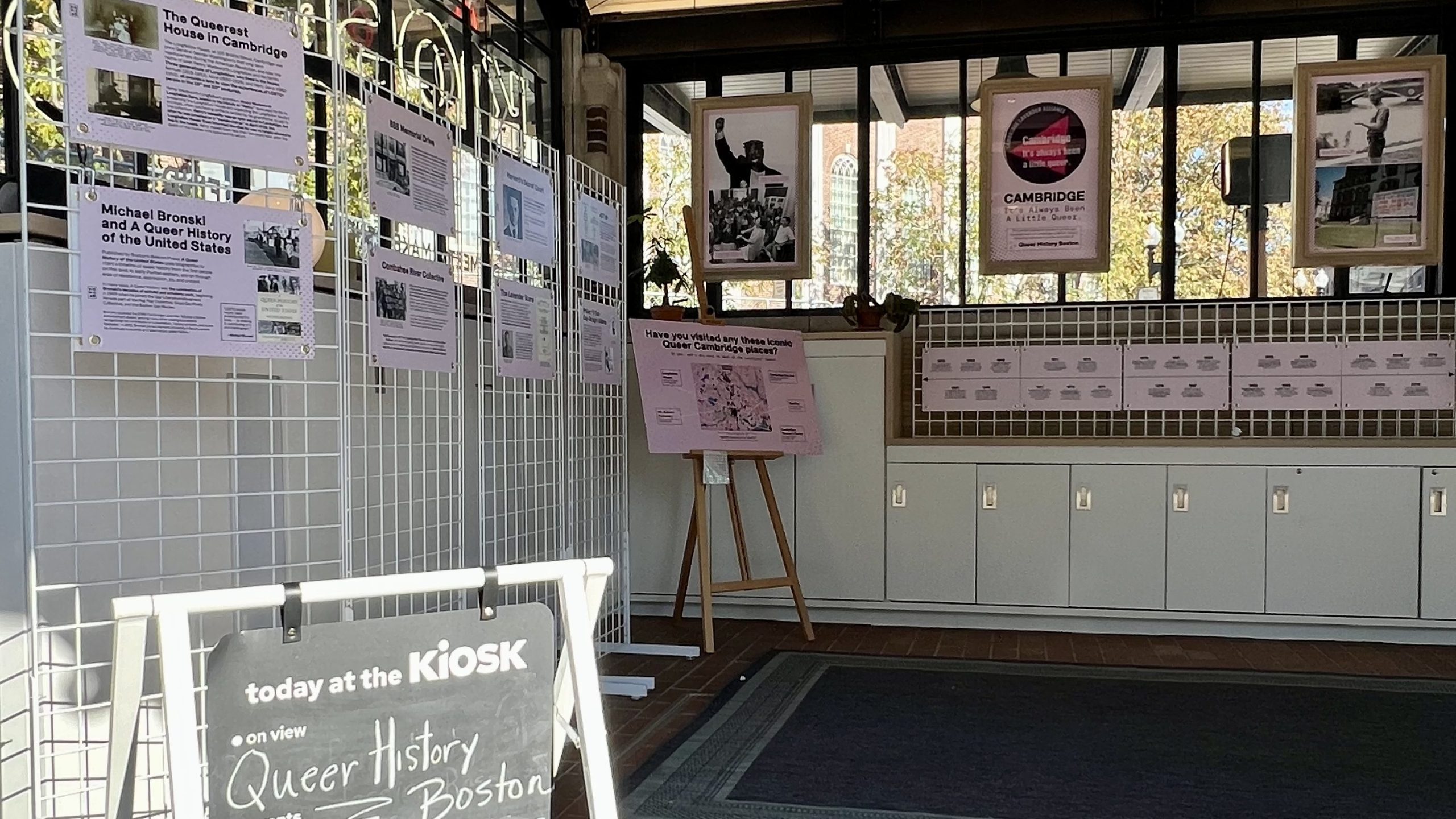 Infographics hang on the walls at the KiOSK for the Queer History exhibition.