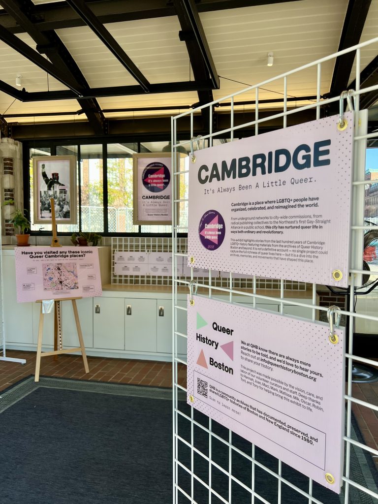 Infographics hang on the walls at the KiOSK for the Queer History exhibition.